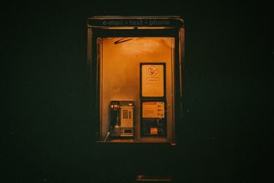 Illuminated telephone booth at night