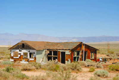 Abandoned house on field against clear sky