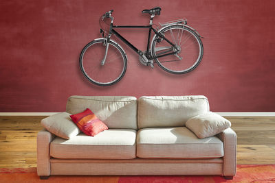 Elegant classical sofa from front in luxurious apartment with a hanging road bike on wall.