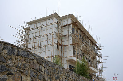 Low angle view of building under construction against clear sky