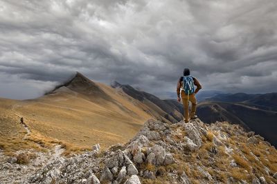 Man standing on mountain against sky