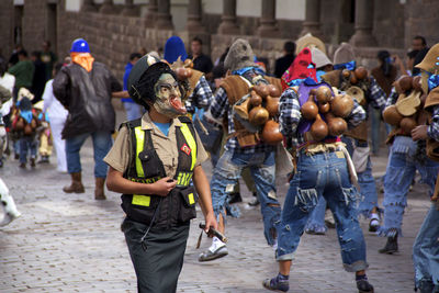 Front view of people dancing on street masked