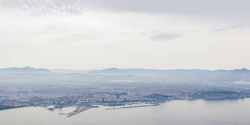 High angle view of cityscape by sea against sky