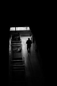 Rear view of silhouette man walking on staircase