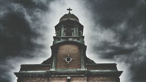 Low angle view of church against cloudy sky