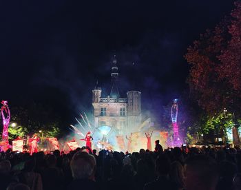 Crowd at music concert against sky at night