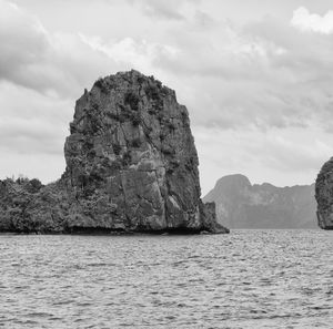 Rock formation in sea against sky