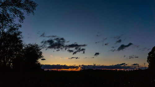 Low angle view of silhouette trees against sky at sunset