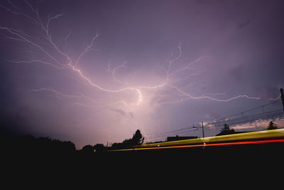 Forked lightning against purple sky at night