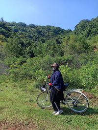 Woman with bicycle on field