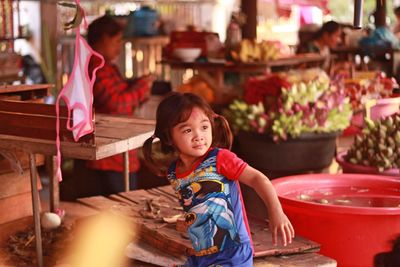 Girl by table at market