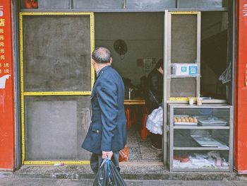Rear view of man working at bus