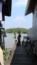 People on shore against sky