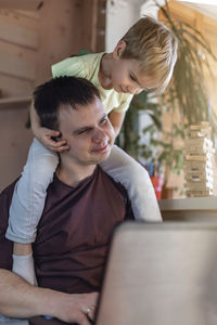 Side view of boy using laptop at home