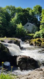 Scenic view of waterfall against sky