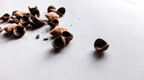 High angle view of roasted coffee beans on white background