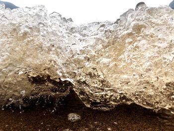 Close-up of rock formation in sea against sky