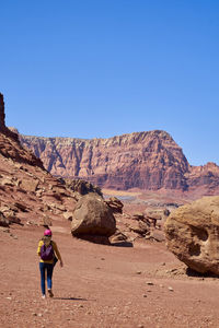 Woman hiking in glen canyon national recreation area, utah. vertical photo.