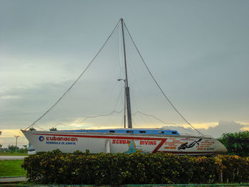 Sailboats moored on shore against sky