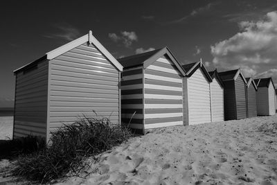 Barn at beach against sky