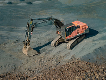 Industrial toothed digger bucket bite the ground in basalt mine. loader constraction excavator