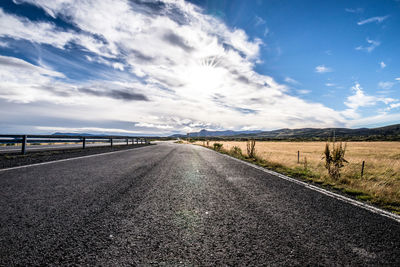 Road by landscape against sky