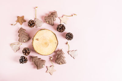 Handmade knitted trees, christmas decorations and pine cones around a cut tree top view