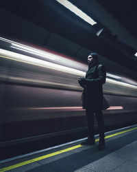 Man standing at railroad station platform