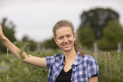 Young woman working as vegetable grower or farmer in the field