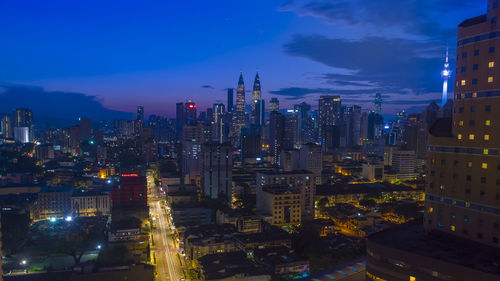 High angle view of illuminated buildings against sky at night