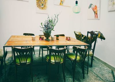 Empty chairs and table against wall