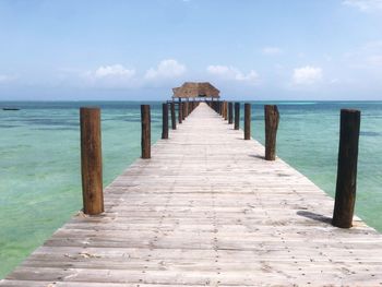 Wooden pier on sea against sky