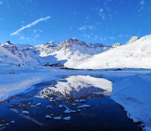 Scenic view of snowcapped mountains against blue sky