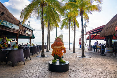 Rear view of woman with palm trees against sky