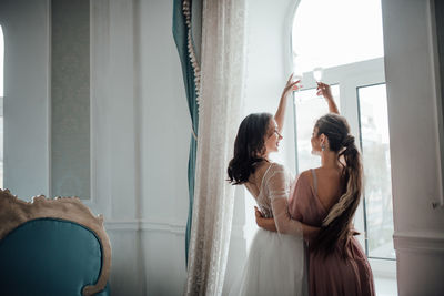 Bridesmaid and bride holding champagne flute