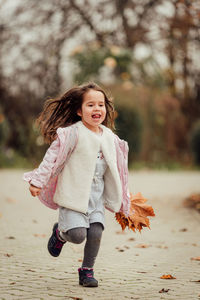 Portrait of cute girl smiling while standing outdoors