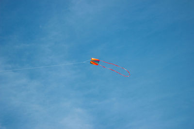 Low angle view of kite flying against blue sky.