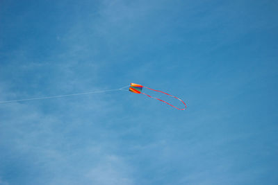 Low angle view of kite flying against blue sky.