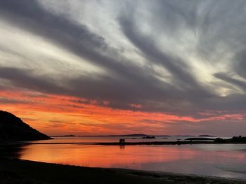 Scenic view of dramatic sky over lake during sunset