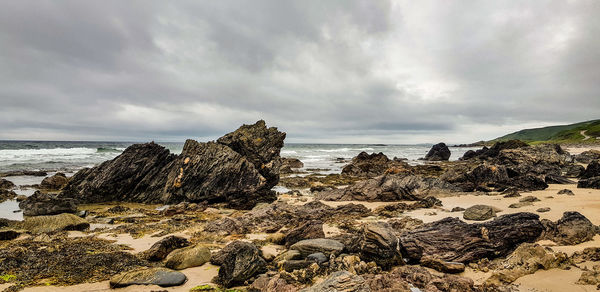 Rocks on beach against sky