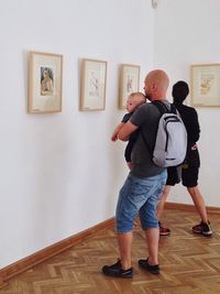 Rear view of men standing in front of museum