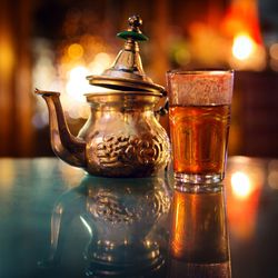 Close-up of tea in glass by teapot on table