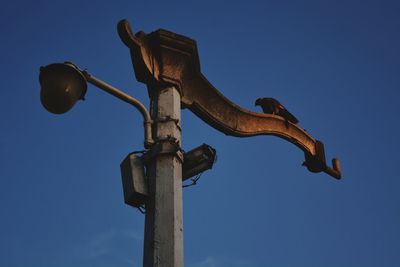 Low angle view of cross against clear blue sky