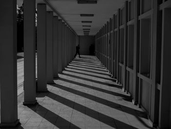 Rear view of person walking on corridor of building