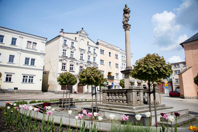 Statue in city against sky