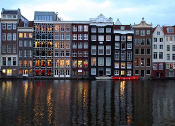 Reflection of buildings on river against sky