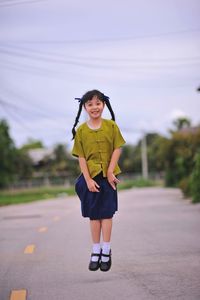 Portrait of girl jumping on road