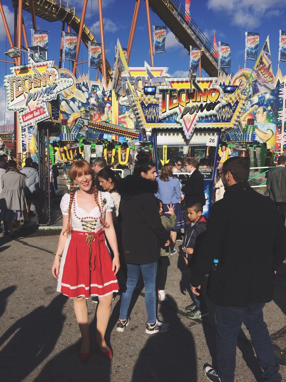 amusement park, leisure activity, arts culture and entertainment, real people, amusement park ride, lifestyles, standing, day, outdoors, looking at camera, togetherness, two people, full length, carousel