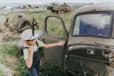 Rear view of woman photographing car on land