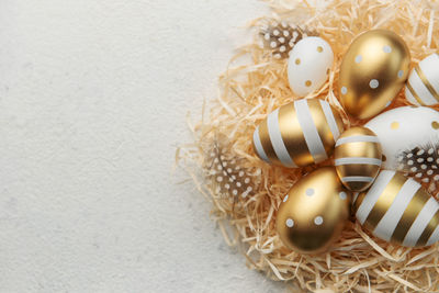 Easter eggs painted with gold paint on a straw background. concept of easter holidays. 